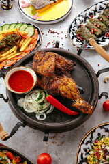 fried chicken on a plate with sauce and vegetables. Uzbek cuisin