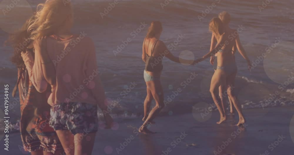 Wall mural Group of friends walking on beach over bokeh lights animation