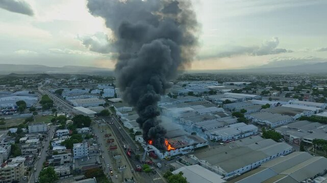 Fierce fire at a factory with a large black smoke cloud, showcasing the chaos and damage caused by the inferno