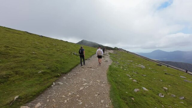 View of Snowdonia National Park, Wales. Man hiking to the peak of the mountain.