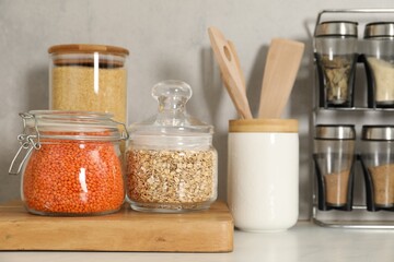 Different types of cereals and legumes in containers on light table