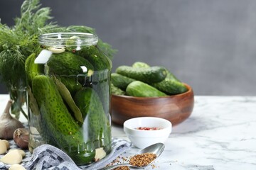 Making pickles. Fresh cucumbers and spices in jar on white marble table