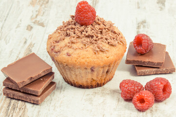 Fresh baked muffin with raspberries and chocolate. Delicious dessert for different occasion