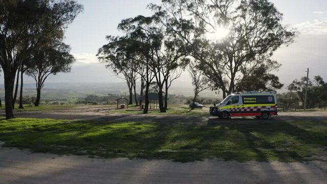 Aerial tracking shot of NSW Ambulance in rural area