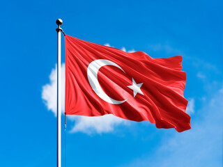 turkey flag flying on blur blue clouds background.