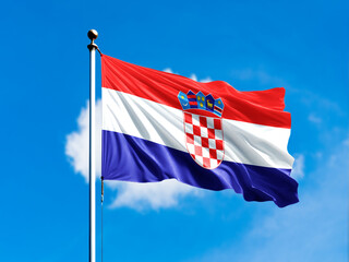 Croatia flag flying on blur blue clouds background.