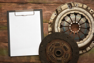 Car clutch basket and repair fix list with copy space on the car service workbench background. Top view. Close up. Car repair list mockup. Service station bill.