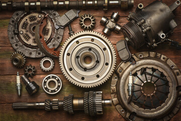 Fototapeta premium Car spare parts on the wooden workbench background. Top view.