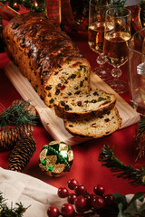 Christmas stollen with raisins dried fruits and glass of champagne on a wooden board