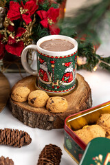 Cup of hot chocolate and cookies on a wooden background with Christmas decorations