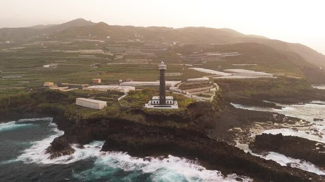 Aerial view of Faro de Punta Cumplida on a scenic cliff surrounded by banana trees and the Atlantic Ocean, Lomo Machin, La Palma, Canary Islands, Spain.