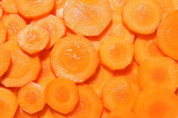 Slices of fresh ripe carrot as background, top view