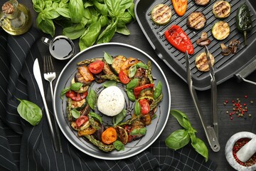 Tasty salad with grilled vegetables and mozzarella cheese served on black wooden table, flat lay