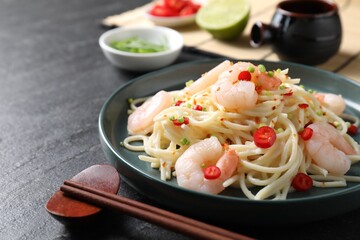 Delicious pasta with shrimps served on black table, closeup