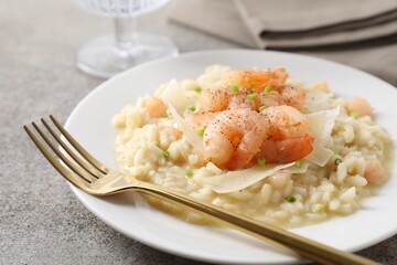 Delicious risotto with shrimps and cheese on grey table, closeup