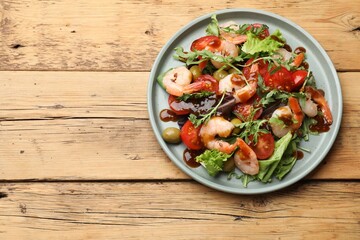 Delicious shrimp salad with vegetables on wooden table, top view. Space for text