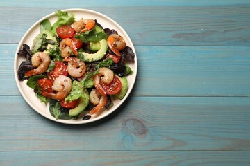 Delicious shrimp salad on light blue wooden table, top view. Space for text