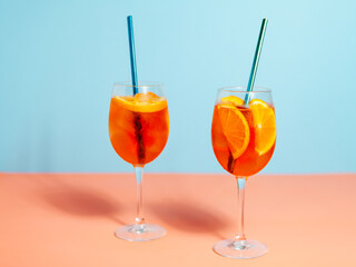 a couple of glasses filled with Aperol Spritz cocktails drinks on top of a table