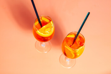 a couple of glasses filled with Aperol Spritz cocktails drinks on top of a table