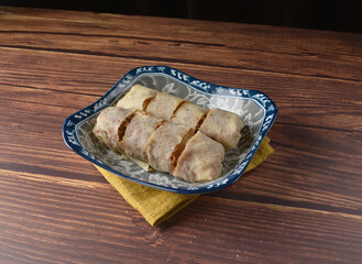 Homemade traditional asian food nyonya Popiah Spring Roll fresh vegetables, bean curd, fried shallots, dried shrimp, sweet chili paste and braised turnip on wood table vegan halal menu for cafe