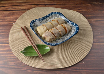 Homemade traditional asian food nyonya Popiah Spring Roll fresh vegetables, bean curd, fried shallots, dried shrimp, sweet chili paste and braised turnip on wood table vegan halal menu for cafe