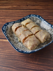 Homemade traditional asian food nyonya Popiah Spring Roll fresh vegetables, bean curd, fried shallots, dried shrimp, sweet chili paste and braised turnip on wood table vegan halal menu for cafe