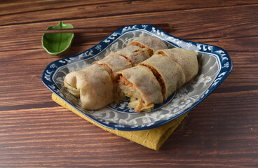 Handmade traditional asian food nyonya Popiah Spring Roll fresh vegetables, bean curd, fried shallots, dried shrimp, sweet chili paste and braised turnip on wood table vegan halal menu for cafe