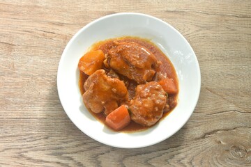 boiled chicken tight with carrot in swet red gravy sauce stew on plate 