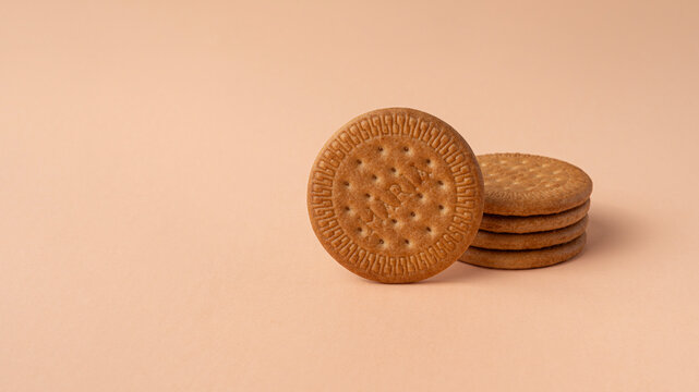 Maria biscuits on pink beige background. Trendy color of the year 2024 - Peach Fuzz. Copy space