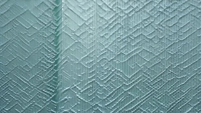 Creating textured wall art in a light blue pattern at a creative studio in the afternoon