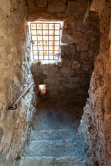 stone staircase in a castle or dungeon with a small window