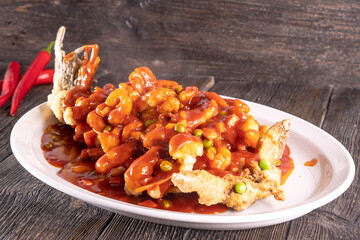 fried fish in sweet and sour sauce on wood table. Chinese food. food concept.