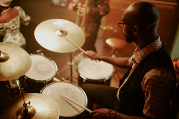 High angle view of unrecognizable young Black man playing drums during jazz concert