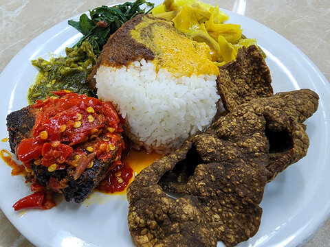 Delicious Padang rice served with crispy Dendeng Paru, spicy Balado Tuna, and savory cassava greens. Nasi Padang is one of famous Indoensian traditional food