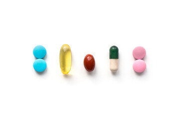 Isolated tablets and pills on white background. Various treatments mixed. Top view.