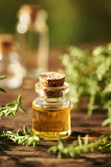 Thyme essential oil in a glass bottle outdoors