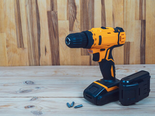 A screwdriver-drill against a wood background, ready for work, is ideal for repairs and construction in the country or at home