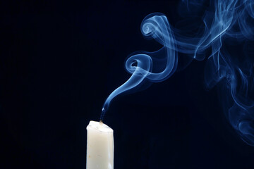 Smoke from an extinguished candle on a dark background. The concept of spirituality and the end of...