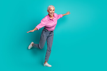 Full size photo of pretty aged woman good mood dance wear shirt isolated on teal color background