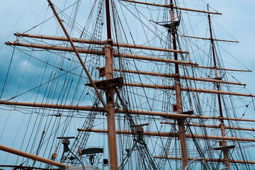 the mast of a ship with a boat