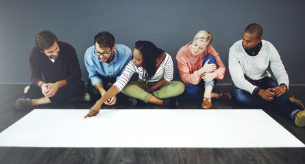 Creative group, planning and collaboration with poster on floor for NGO, charity or awareness campaign at office. Young people, diversity or billboard sign for community advertising on mockup space