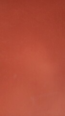 Red rough wall as texture and background. Red background.  The cement walls are painted red. The surface of the plastered wall is uneven and has rough marks. Red color texture pattern.  
