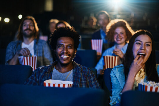 Diverse group of friends enjoying a movie together in a cinema