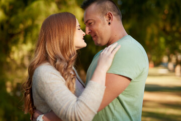 Fototapeta premium Outdoor, couple and smile with admiration for relationship, connection and bonding together on date. Happy people, woman and man with hug for love, affection and commitment with security in Canada