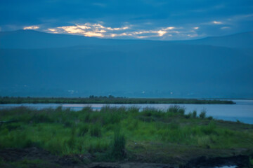 Tranquil lake with misty mountains at dawn