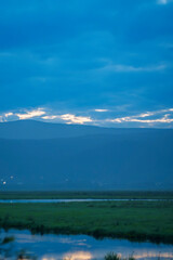 Tranquil lake with misty mountains at dawn