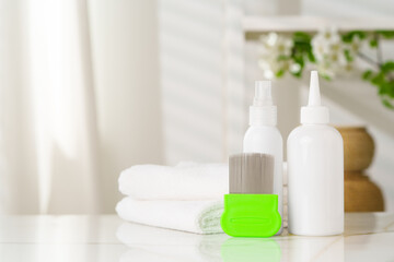 Bottles of Lice Treatment Products and a Comb on a Countertop