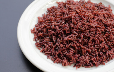 Cooked black berry rice on white plate