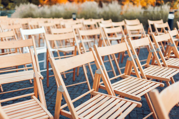 Empty wooden chairs left outdoors after conference or wedding ceremony. Business meeting ended. Nobody