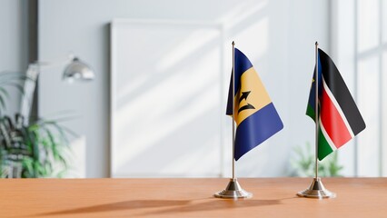 FLAGS OF BARBADOS AND SOUTH SUDAN ON TABLE